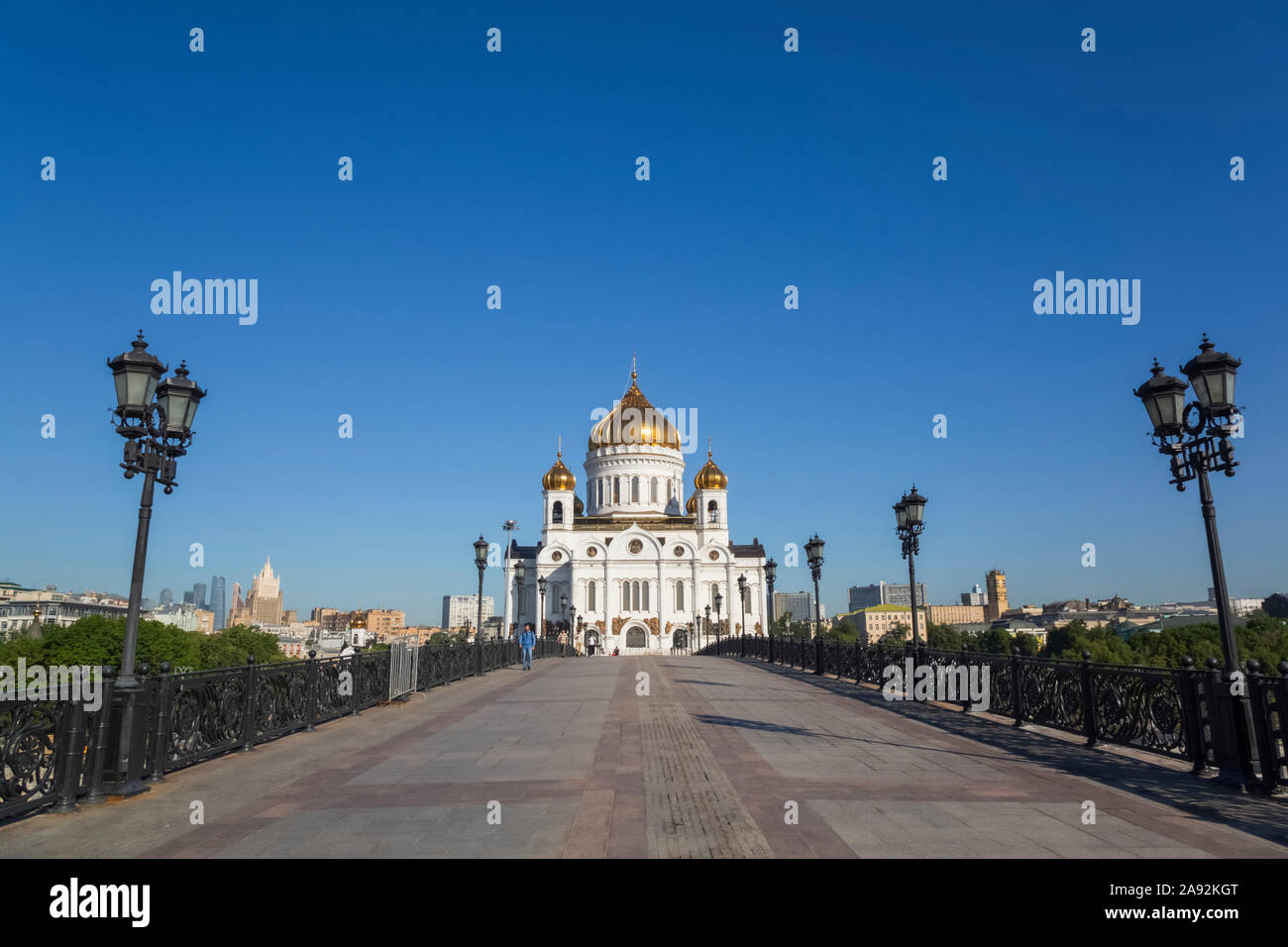 Una lunga passerella che conduce alla Cattedrale di Cristo Salvatore con cupole di cipolla d'oro contro un cielo blu luminoso, Chiesa ortodossa russa (Mosca Patr... Foto Stock