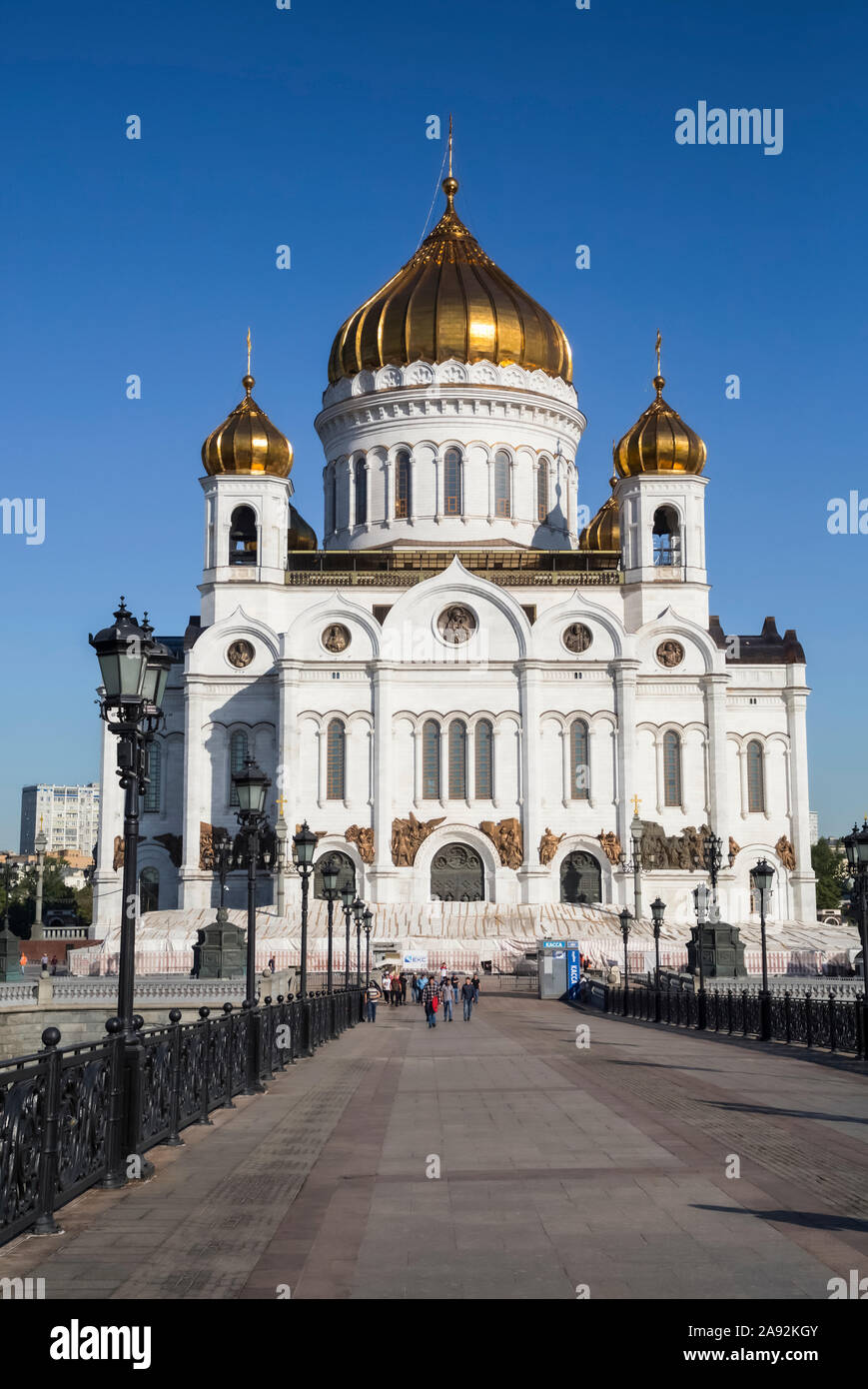 Una lunga passerella che conduce alla Cattedrale di Cristo Salvatore con cupole di cipolla d'oro contro un cielo blu luminoso, Chiesa ortodossa russa (Mosca Patr... Foto Stock