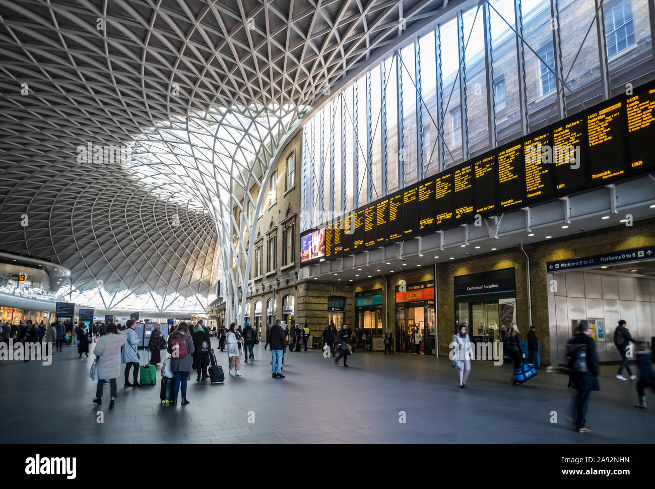 All'interno della stazione ferroviaria King's Cross di Londra con viaggiatori e negozi; Londra, Inghilterra Foto Stock