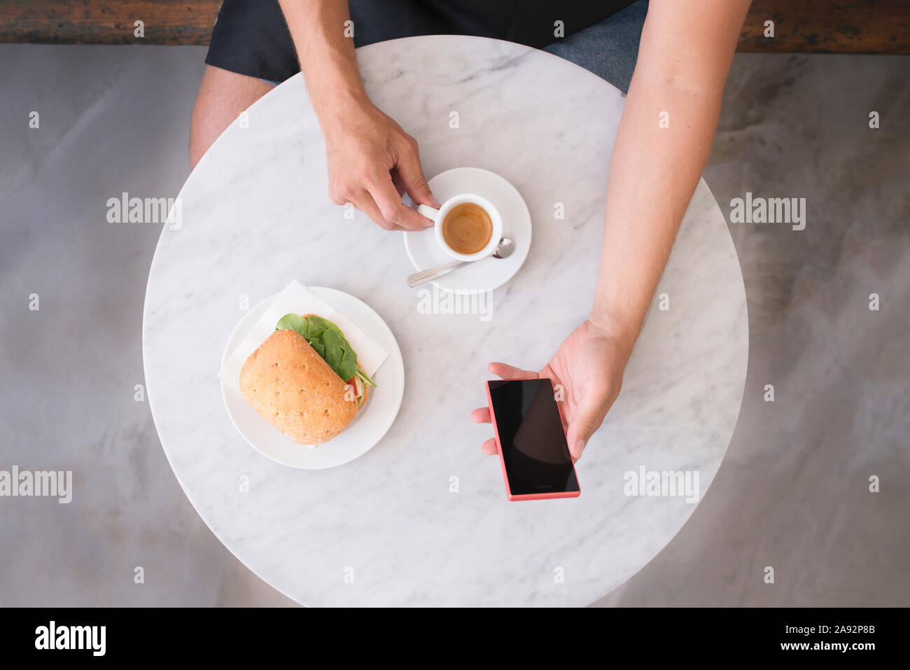 Utilizzando il telefono in pausa caffè Foto Stock