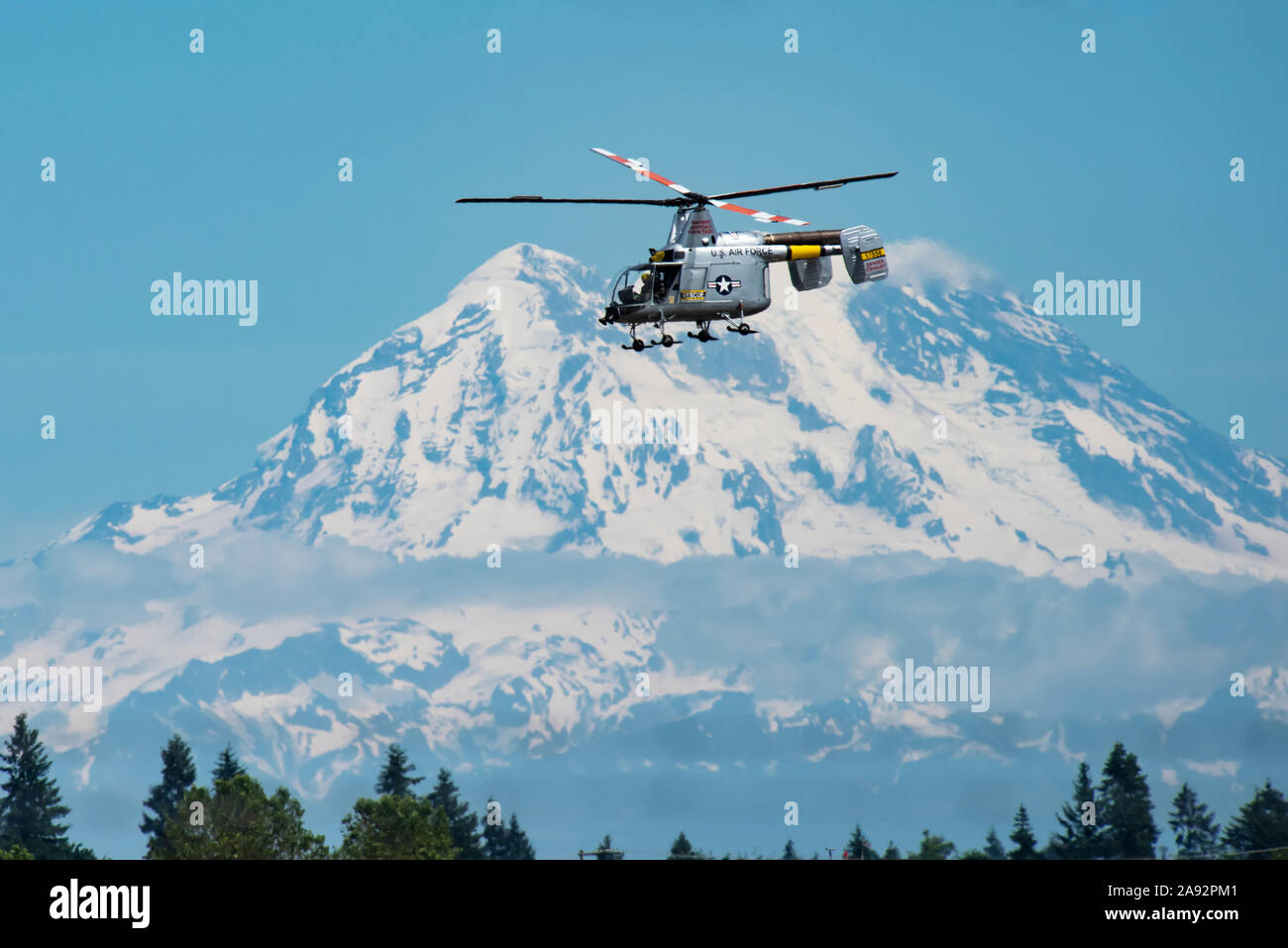 Kaman HH-43F Huskie Helicopter, di proprietà del Museo Olimpico del volo, esecuzione di manovre aerobiche con il Monte Rainier sullo sfondo, 2019 olym... Foto Stock