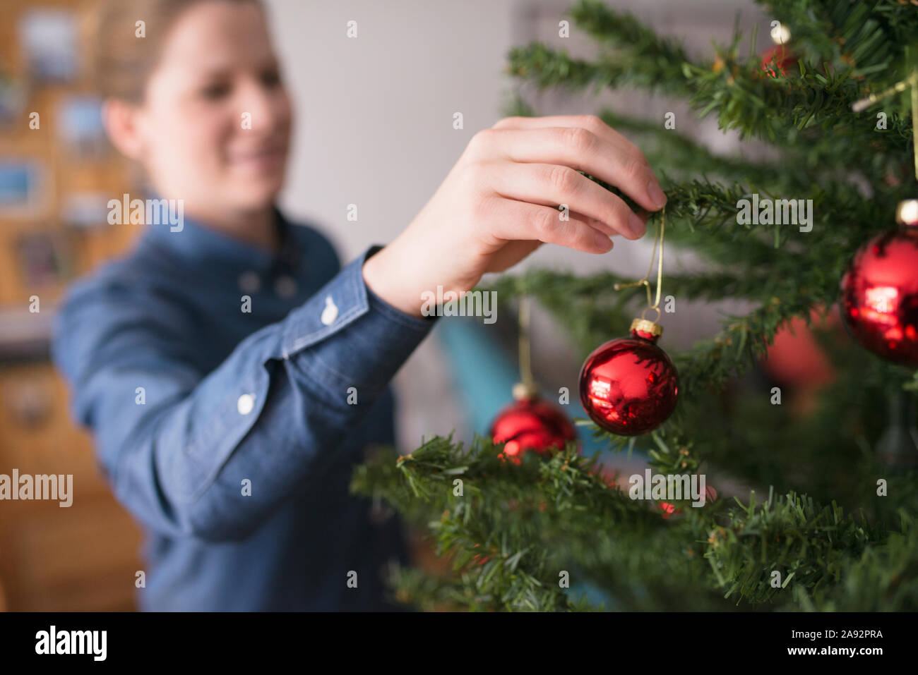 Donna decorare albero di Natale Foto Stock
