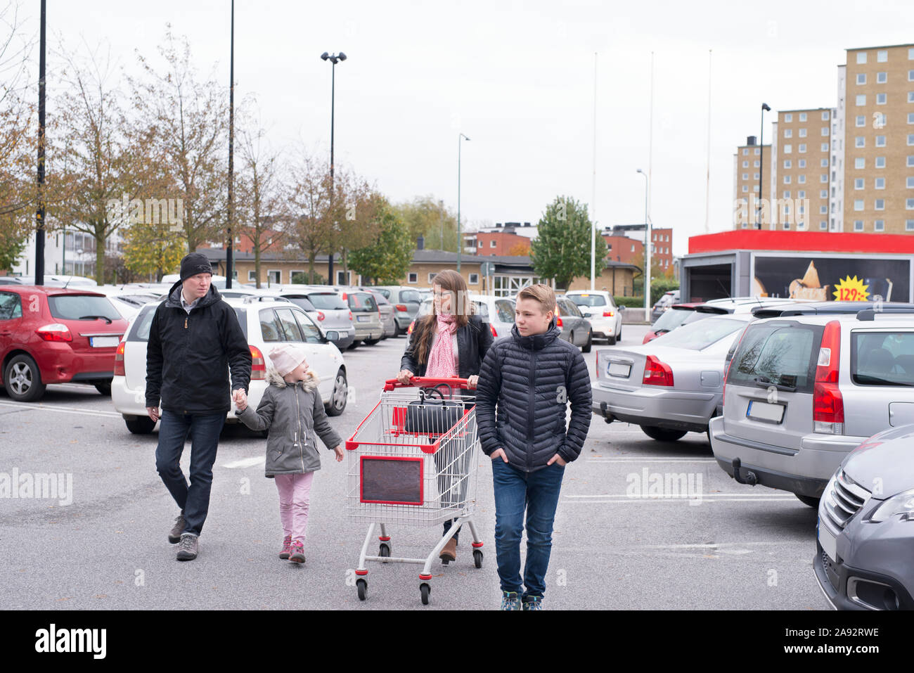 La famiglia sul parcheggio del negozio Foto Stock