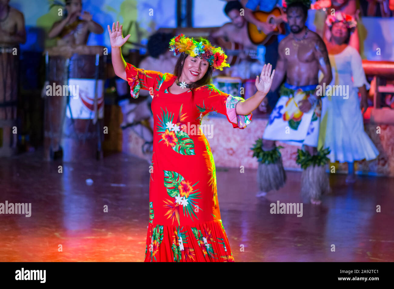 Ballerina polinesiana in abito rosso che si esibisce sul palco; Hanga Roa, Isola di Pasqua, Cile Foto Stock