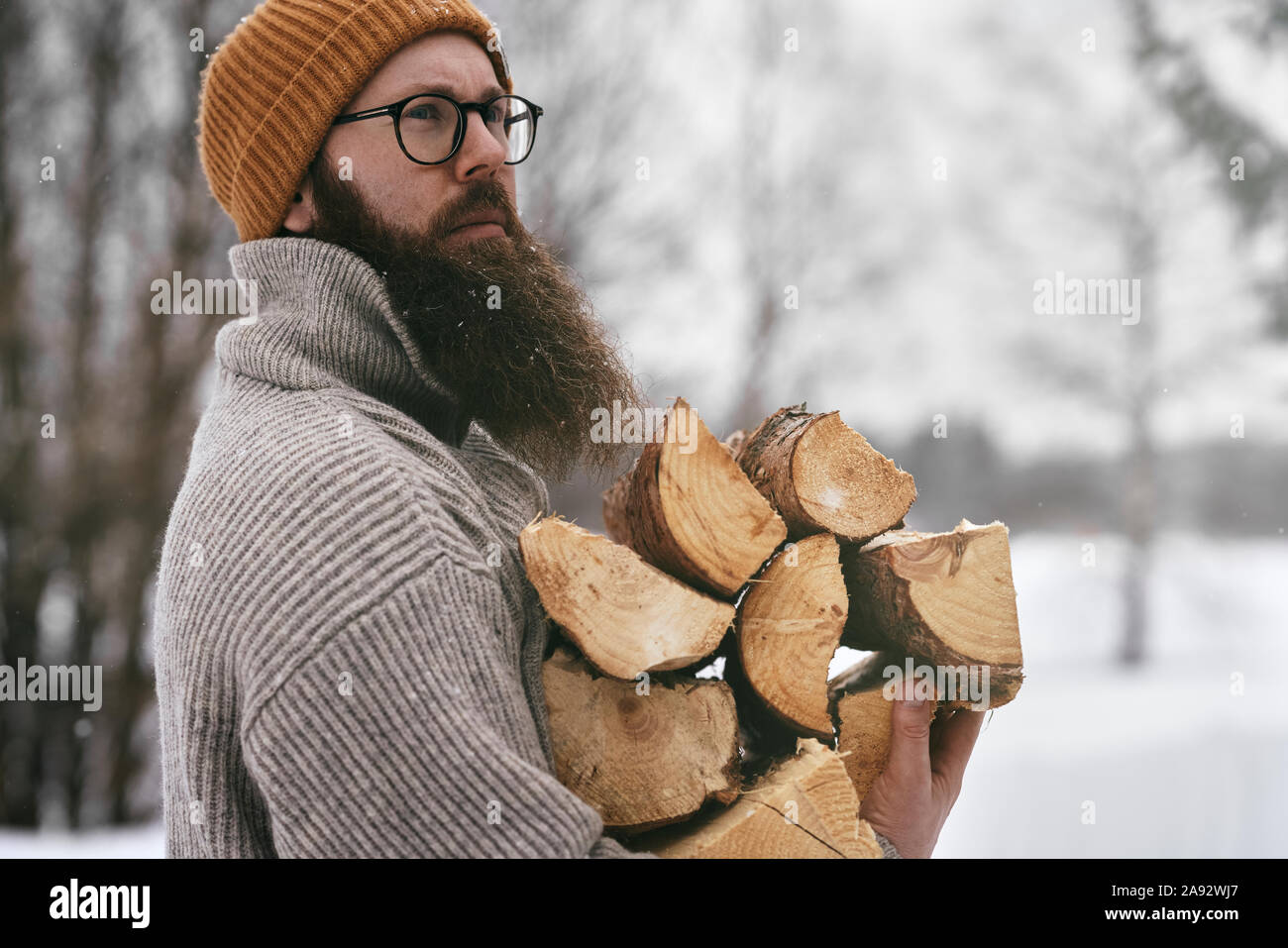 Uomo con fuoco a legna Foto Stock
