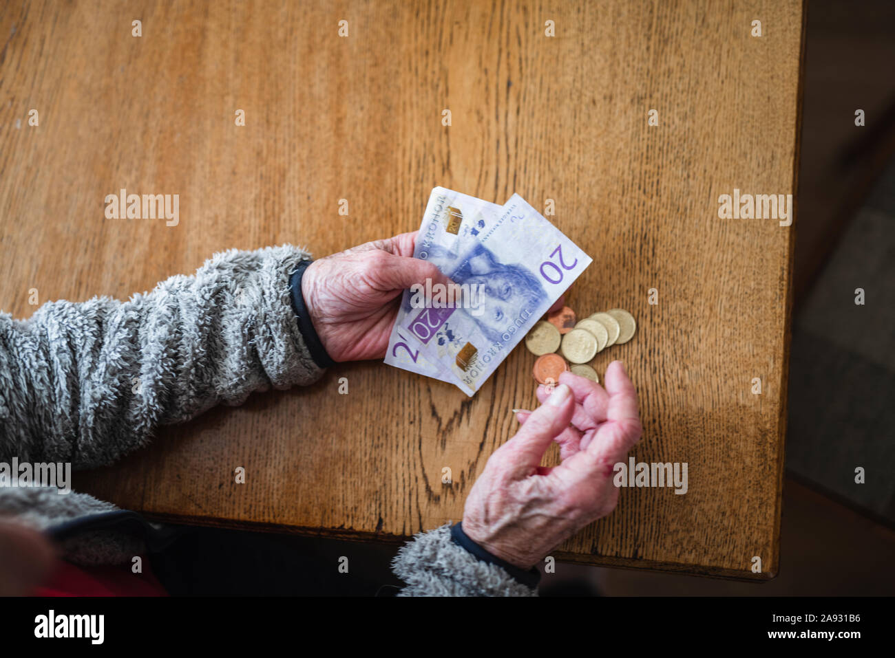 Mani tenendo le banconote e le monete in euro Foto Stock