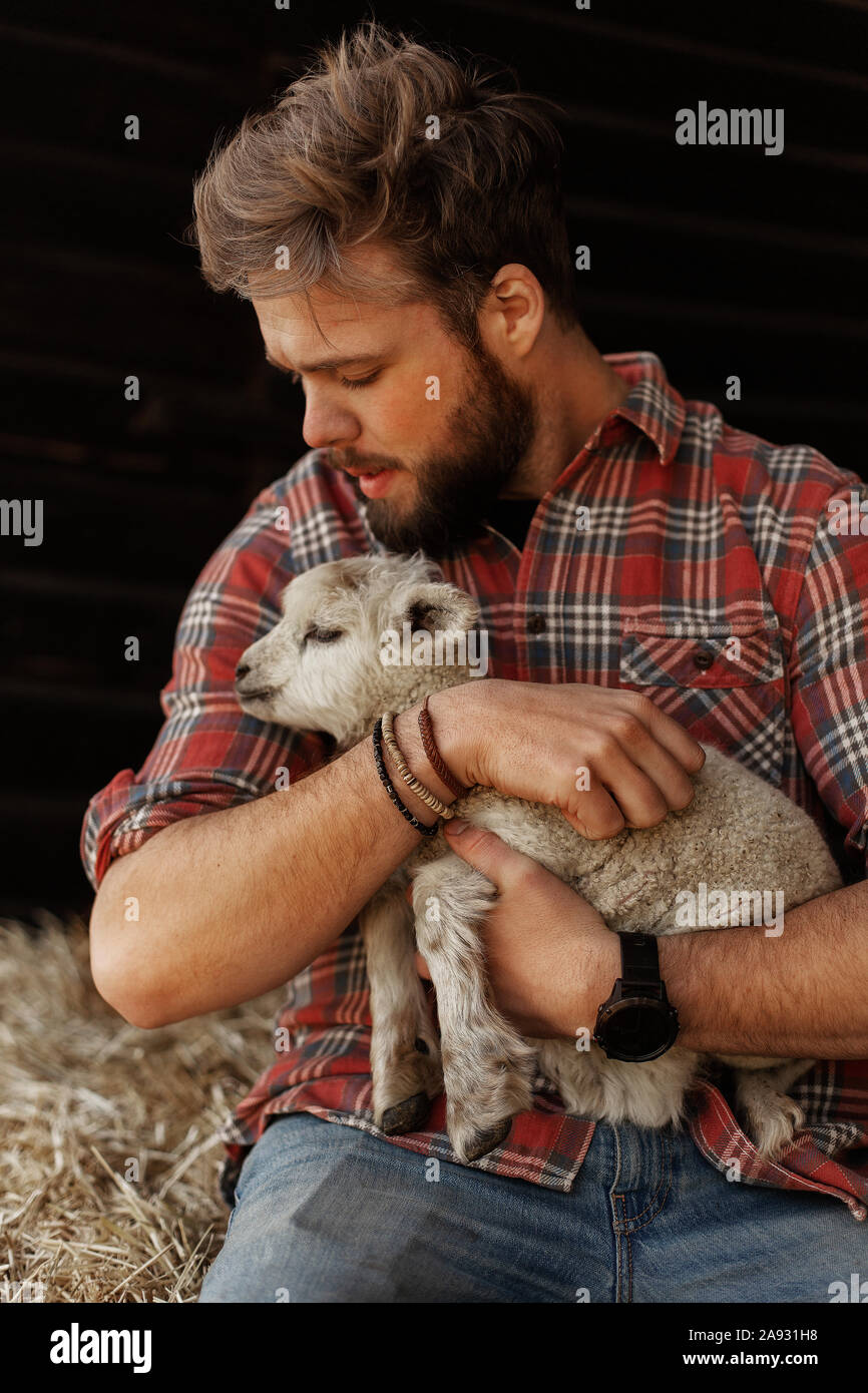 L'agricoltore che detiene di agnello Foto Stock