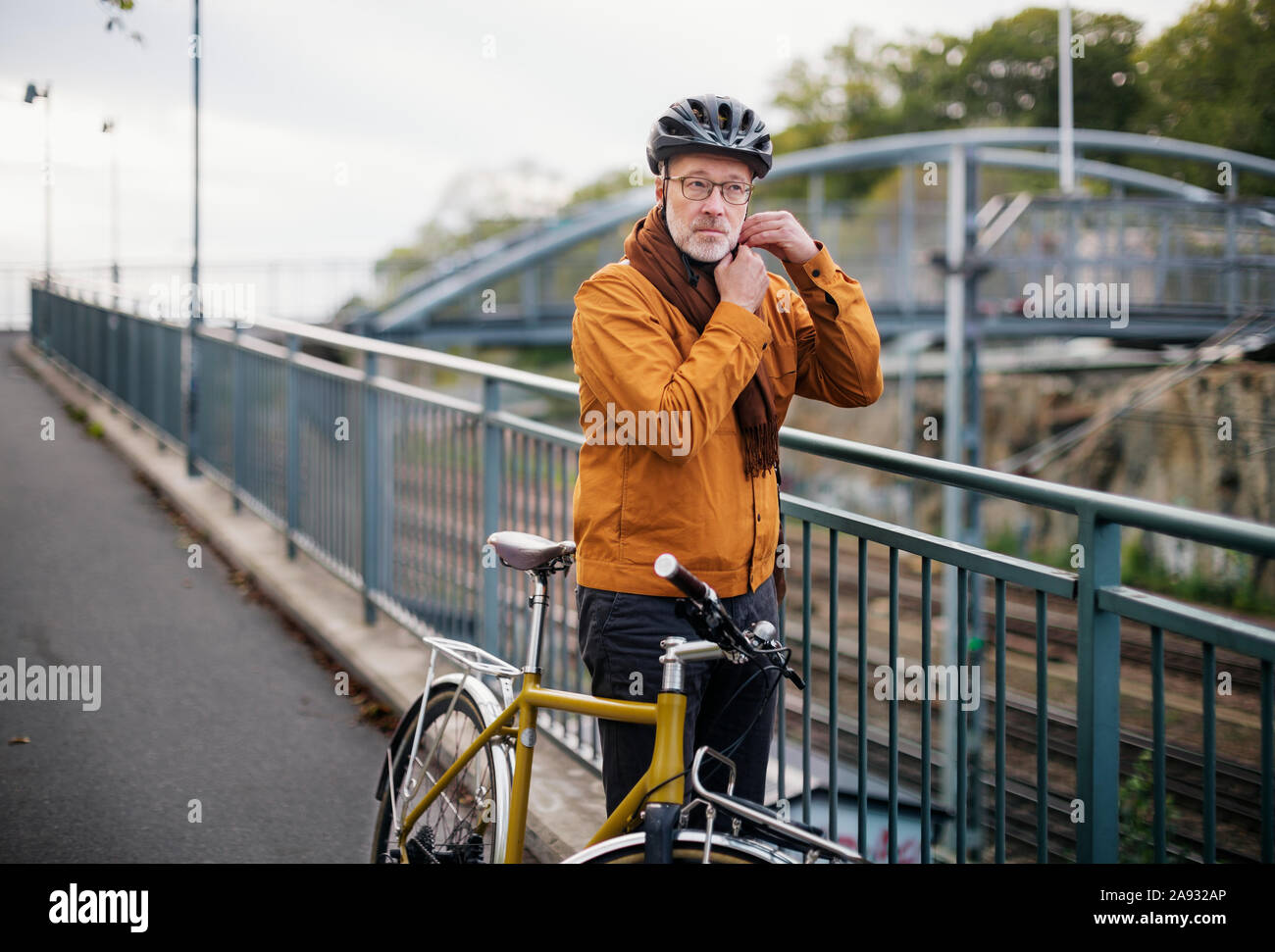 Uomo maturo mettendo il ciclismo casco su Foto Stock