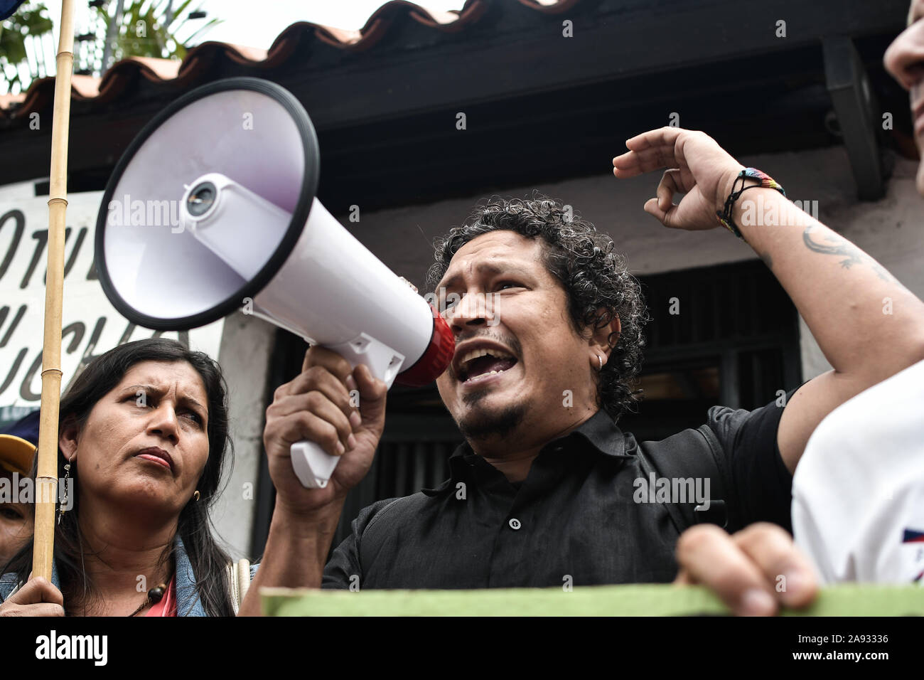 Sostenitore gridando in un megafono durante la protesta.i sostenitori dei movimenti sociali e il venezuelano della gioventù comunista protesta a sostegno dell ex presidente Evo Morales di fronte all'ambasciata boliviana. Il presidente del paese si è dimesso dopo una forte protesta contro la sua rielezione e per aver rifiutato di condurre una verifica dei voti. Foto Stock