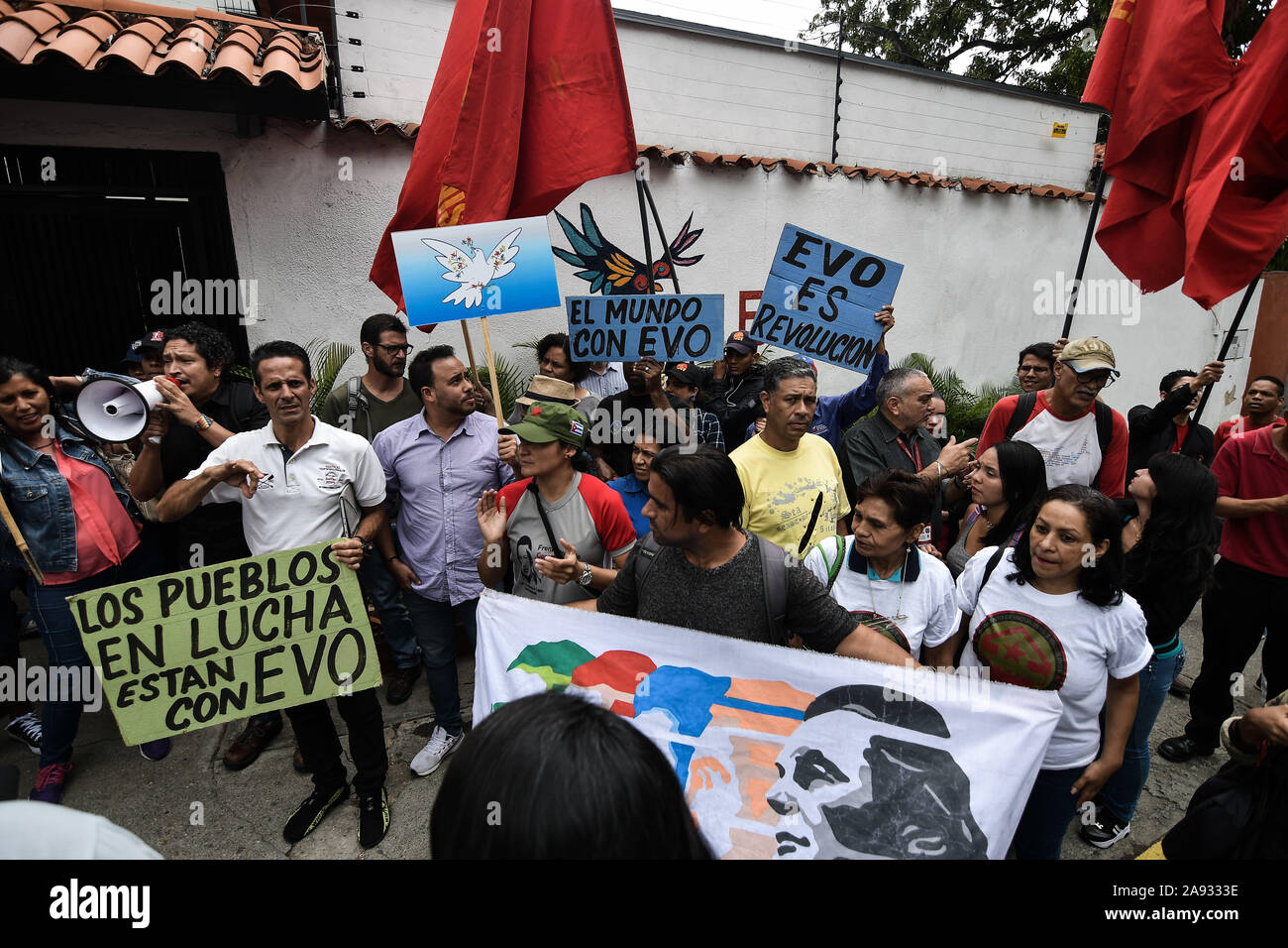 La folla di tifosi con cartelli e bandiere presso l ambasciata Boliviana durante la protesta.i sostenitori dei movimenti sociali e il venezuelano della gioventù comunista protesta a sostegno dell ex presidente Evo Morales di fronte all'ambasciata boliviana. Il presidente del paese si è dimesso dopo una forte protesta contro la sua rielezione e per aver rifiutato di condurre una verifica dei voti. Foto Stock