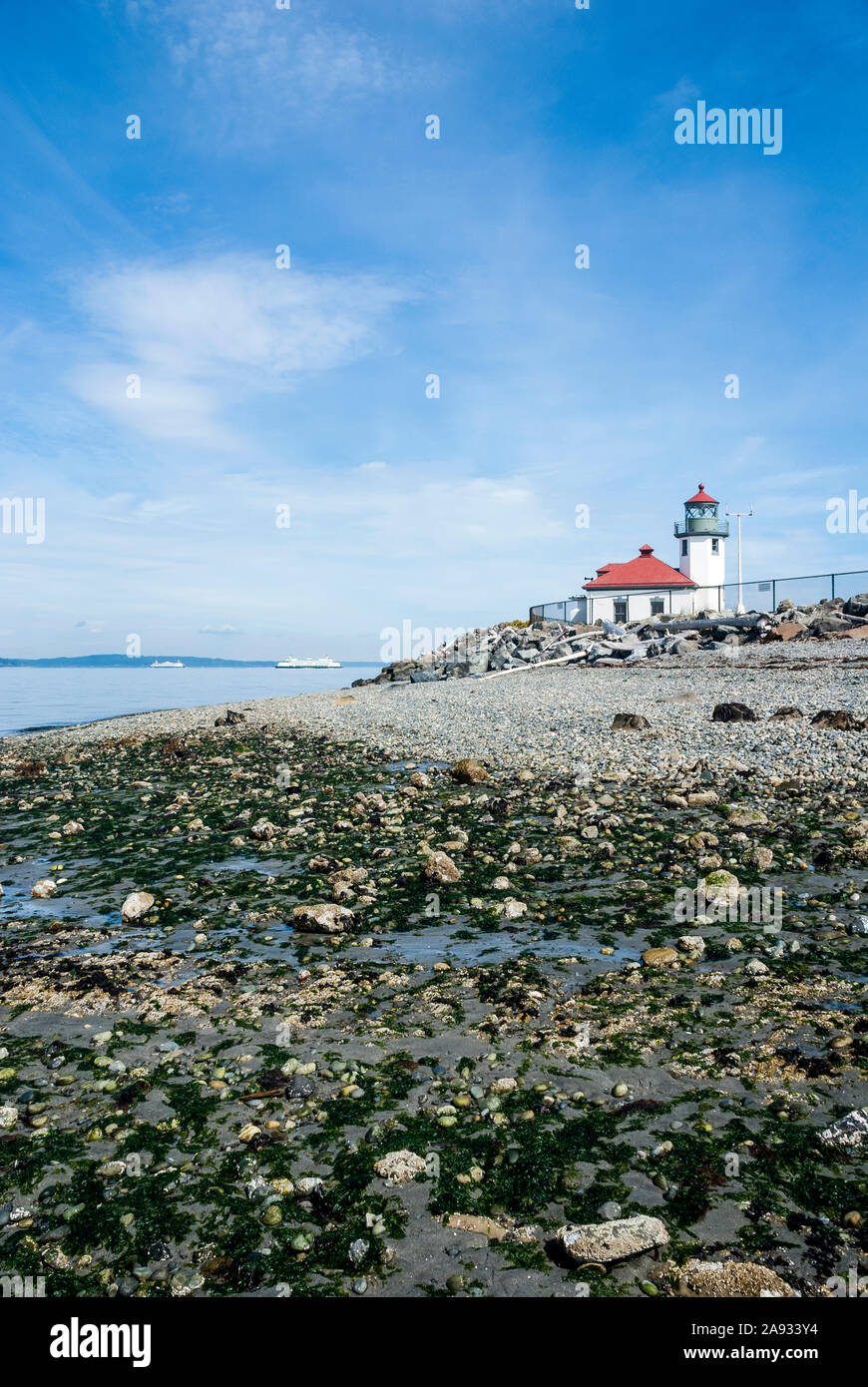 Alki Point Lighthouse in West Seattle, Washington. Ci sono due traghetti in Puget Sound in background. Foto Stock