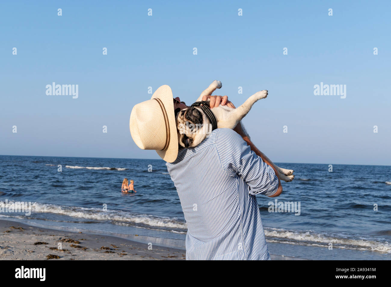 Uomo con pug in mare Foto Stock