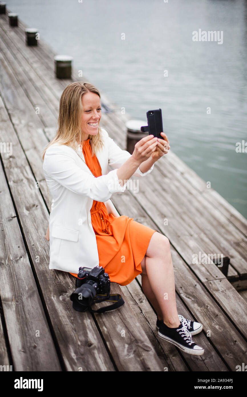 Donna con tenendo selfie con un telefono cellulare Foto Stock