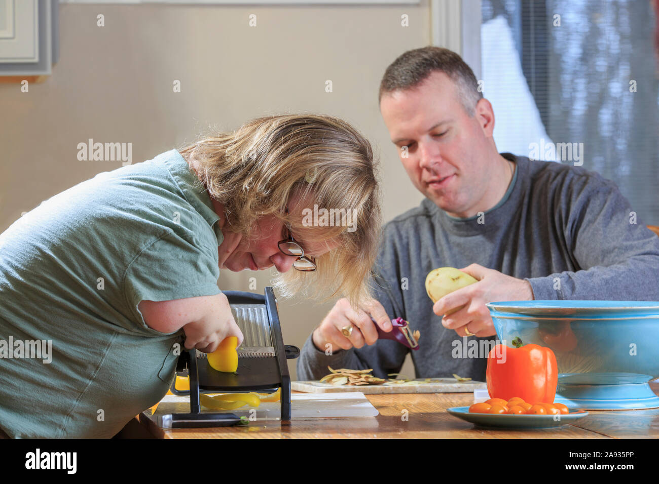 Donna con sindrome di catrame di reticolo di verdure con suo marito in cucina Foto Stock