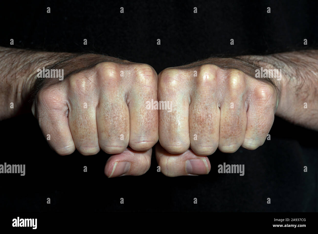 L uomo è rinserrata pugni affiancati, vicino. Foto Stock