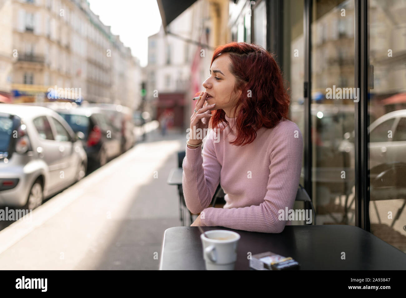 Donna di fumare in outdoor cafe Foto Stock