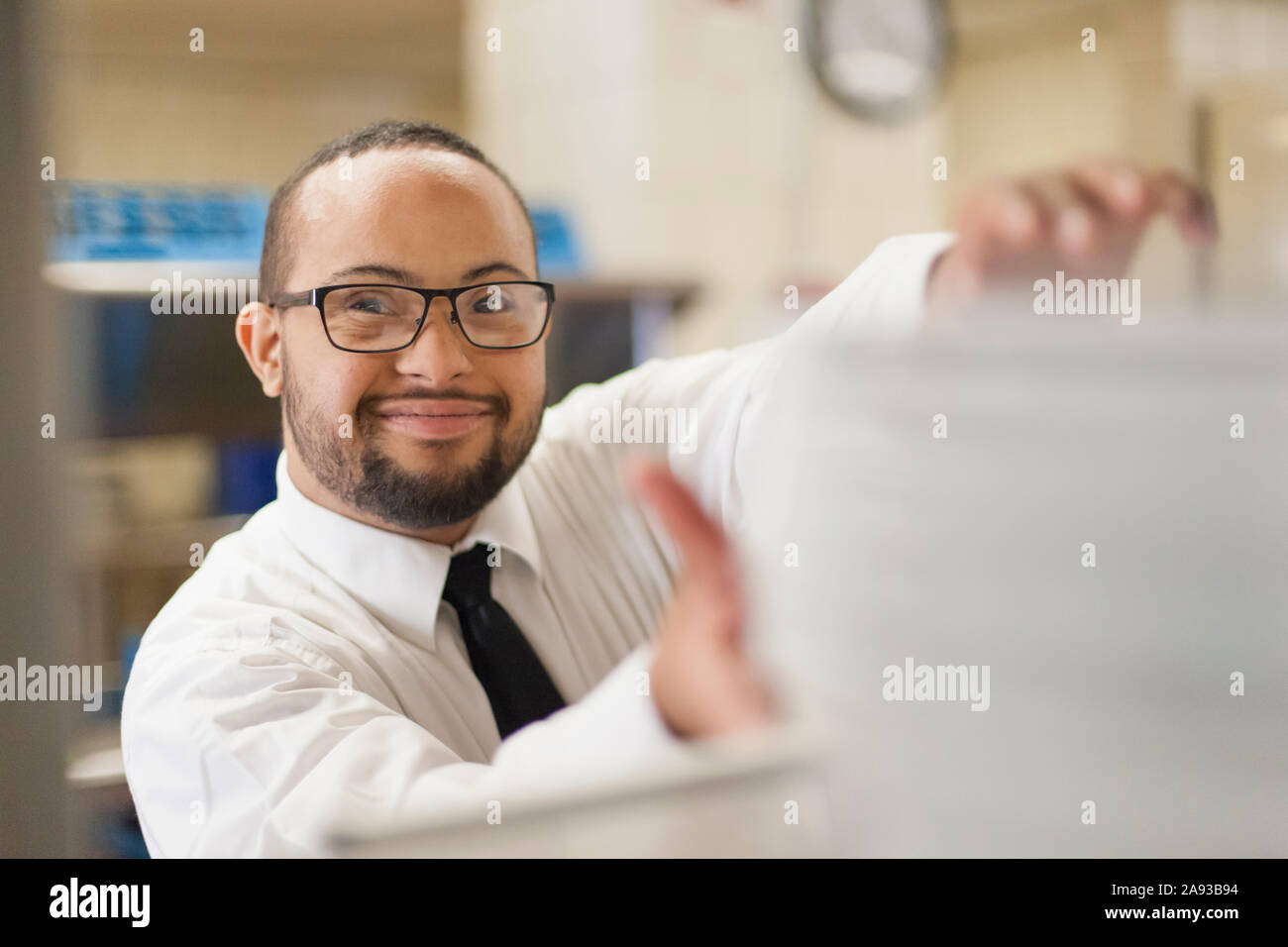 L'uomo afroamericano con la sindrome di Down come un cameriere che lavora nel ristorante Foto Stock