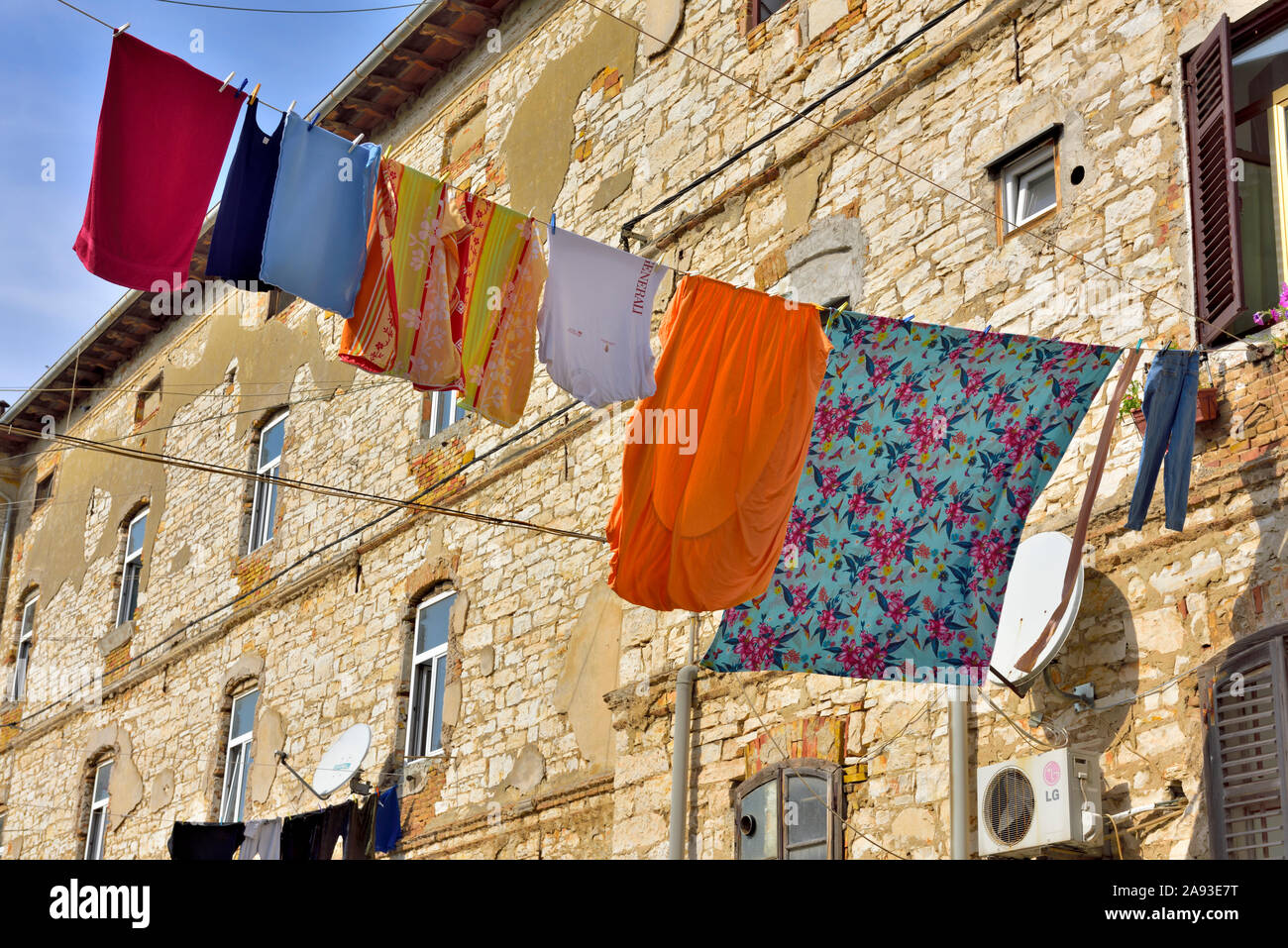 Biancheria stesa ad asciugare sul tettuccio di linea di lavaggio dal vecchio edificio in pietra Foto Stock