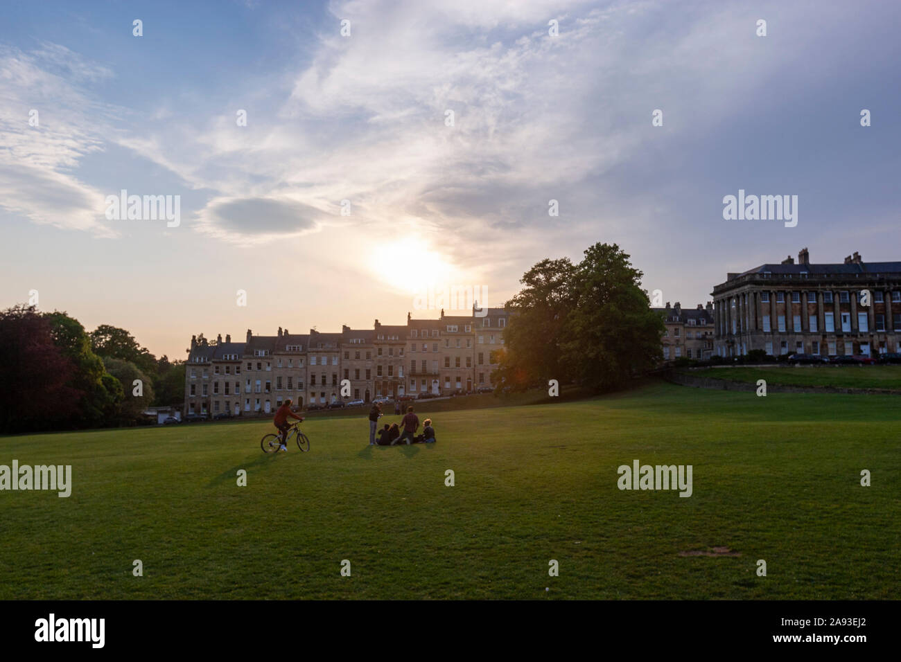Più giovane al tramonto in un parco visualizzazione edifici theMarlborough dal parco vicino Royal Crescent, una fila di 30 case a schiera, bagno, Somerset, Inghilterra, Regno Unito Foto Stock