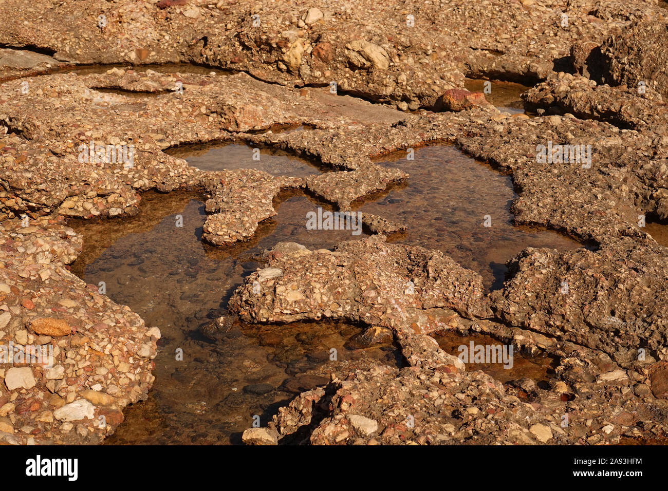 Acqua di sale mare pozzanghere in roccia che rimangono dopo la maree fuori Foto Stock