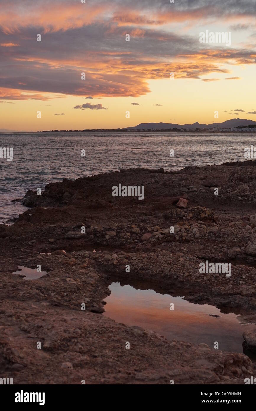Pozze di mare sulla spiaggia al tramonto Foto Stock