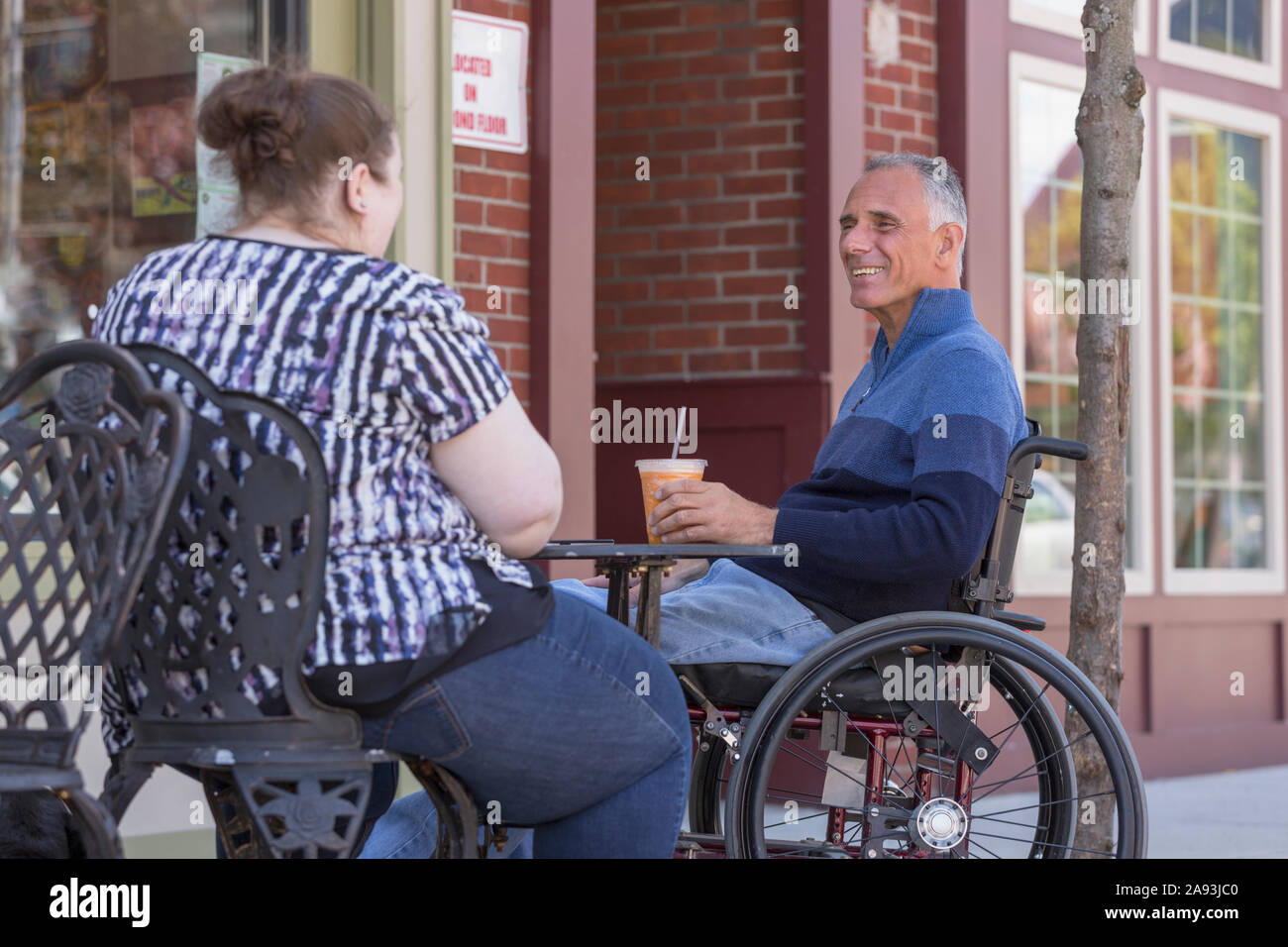Donna con disabilità visiva seduta ad un cafÃ© con lei padre Foto Stock