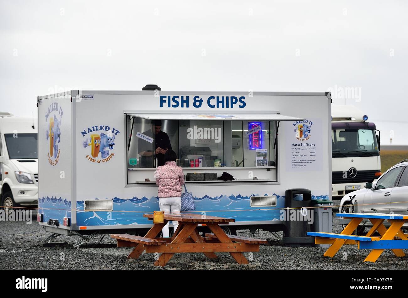 Jökulsárlón, Islanda. Un mobile pesce e patatine shop services turisti lungo una linea costiera e Iceberg Jökulsárlón a. Foto Stock