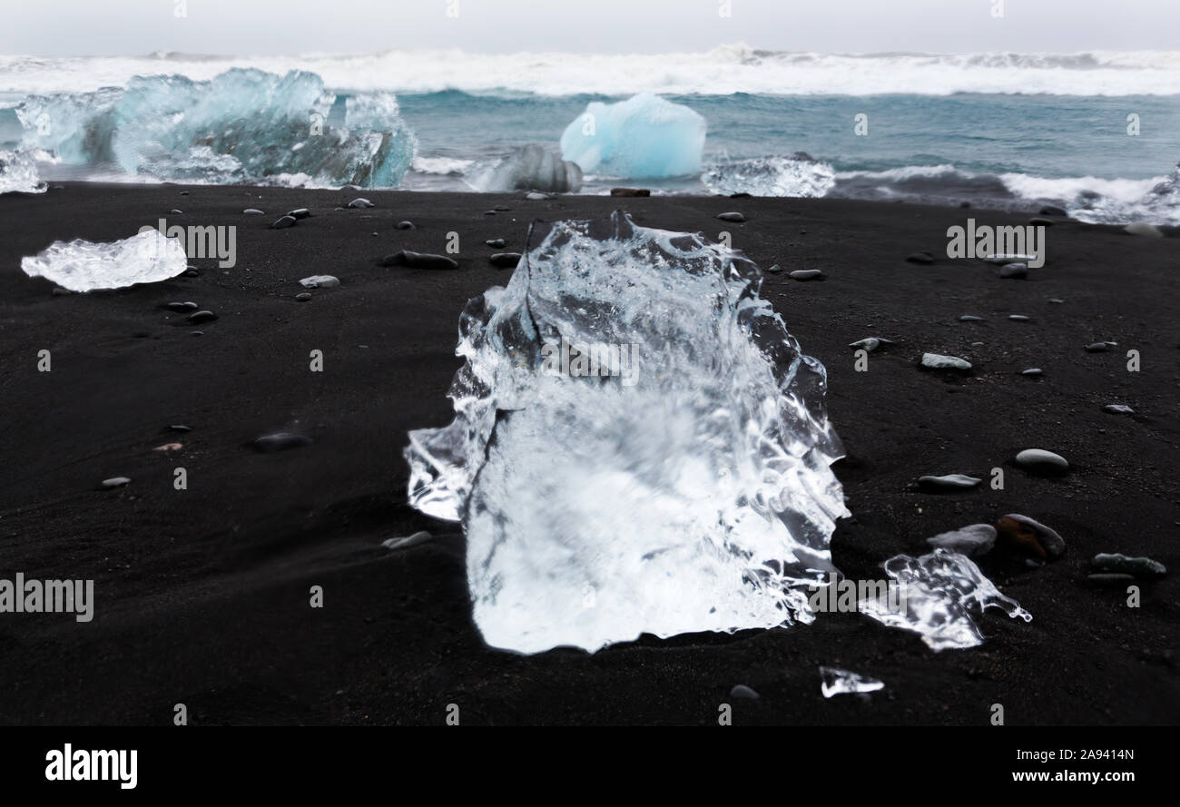 Luccicante pezzi di ghiaccio lavare fino su un flusso di lava che spiaggia di sabbia nera nel Nord Atlantico, dando l'aspetto di diamanti sulla spiaggia a Jokulsarlon glaci Foto Stock