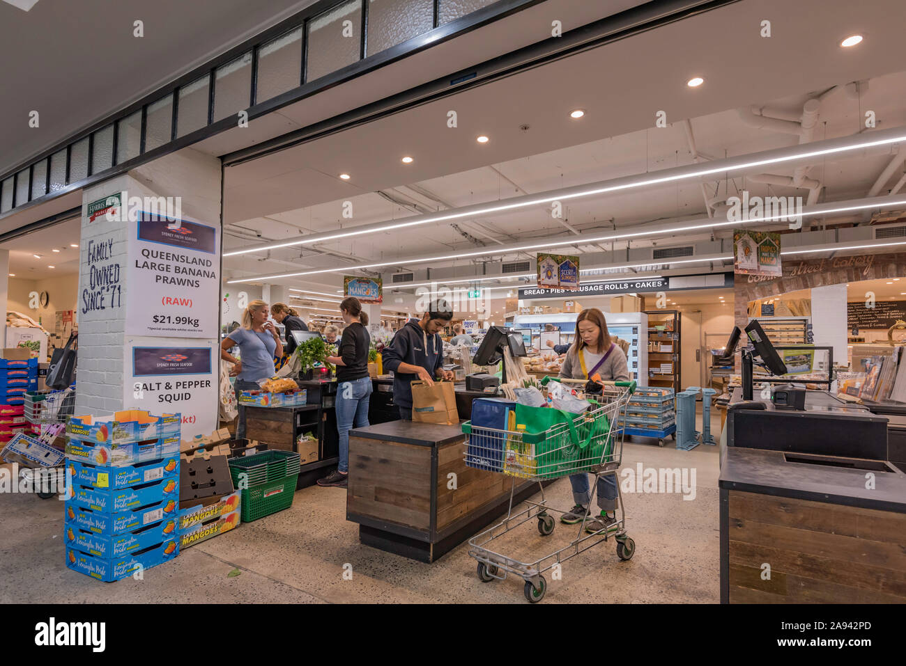 People shopping per il pane a base di carne e di altri alimenti a Harris Farm supermercato su Sydney North Shore utilizzando cartone o loro riutilizzabile borse per lo shopping Foto Stock