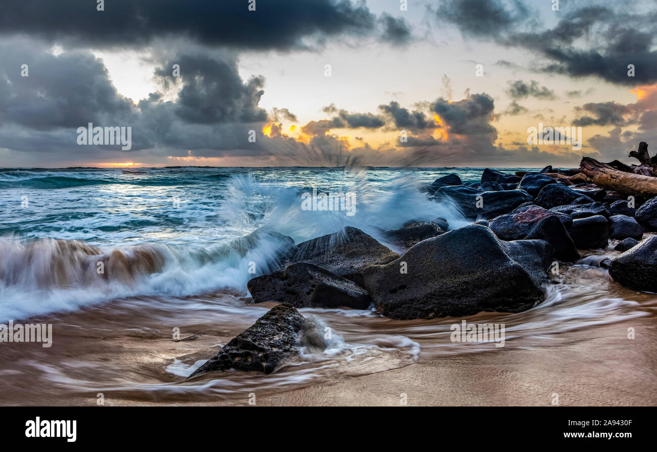 Alba attraverso le nuvole sull'oceano Pacifico, vista dalla spiaggia di Lydgate; Kapaa, Kauai, Hawaii, Stati Uniti d'America Foto Stock