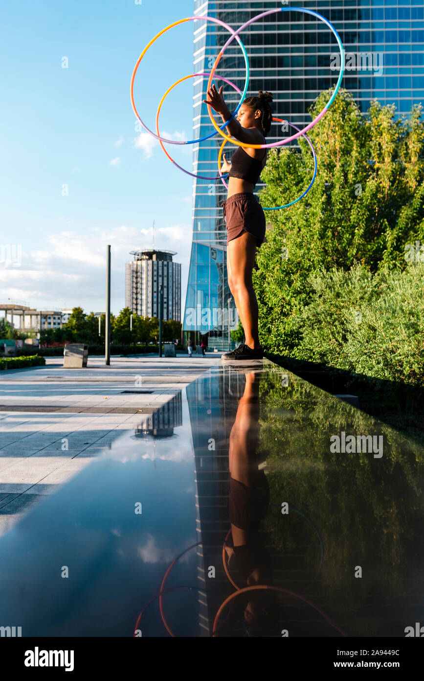 Giovane bella donna in costume di circo gioca con hula hoop nel parco Foto  stock - Alamy