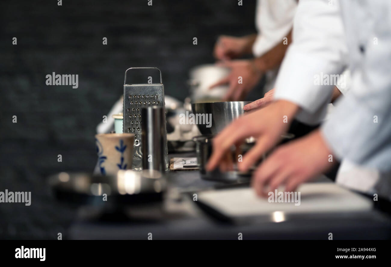 Team professionale di cuochi prepara il cibo in una cucina commerciale. Cuoce nel processo di produzione del sistema catering. Vista interna di un pro caterin Foto Stock