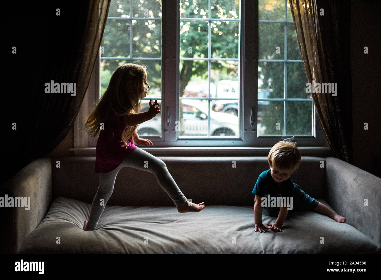 Due bambini di saltare sul loro lettino. Foto Stock