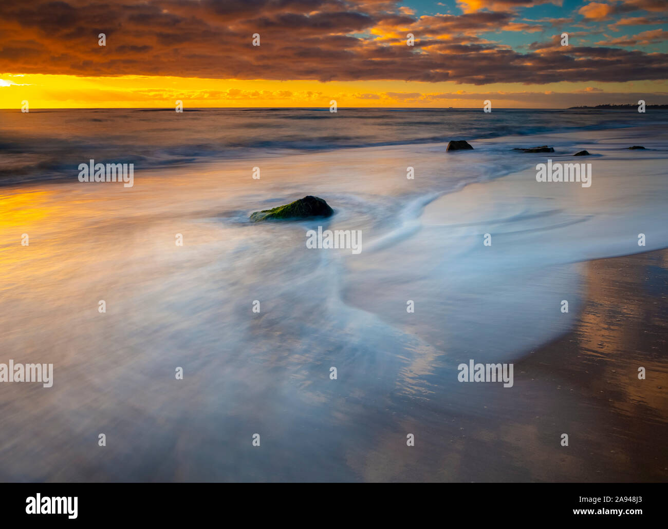 Alba sulla spiaggia e sull'oceano con marea che si diletta sulla sabbia; Kauai, Hawaii, Stati Uniti d'America Foto Stock