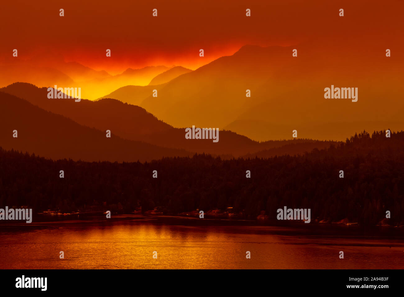 Bagliore dell'alba attraverso il fumo di fuoco della foresta, Gibsons Landing, Sunshine Coast; British Columbia, Canada Foto Stock