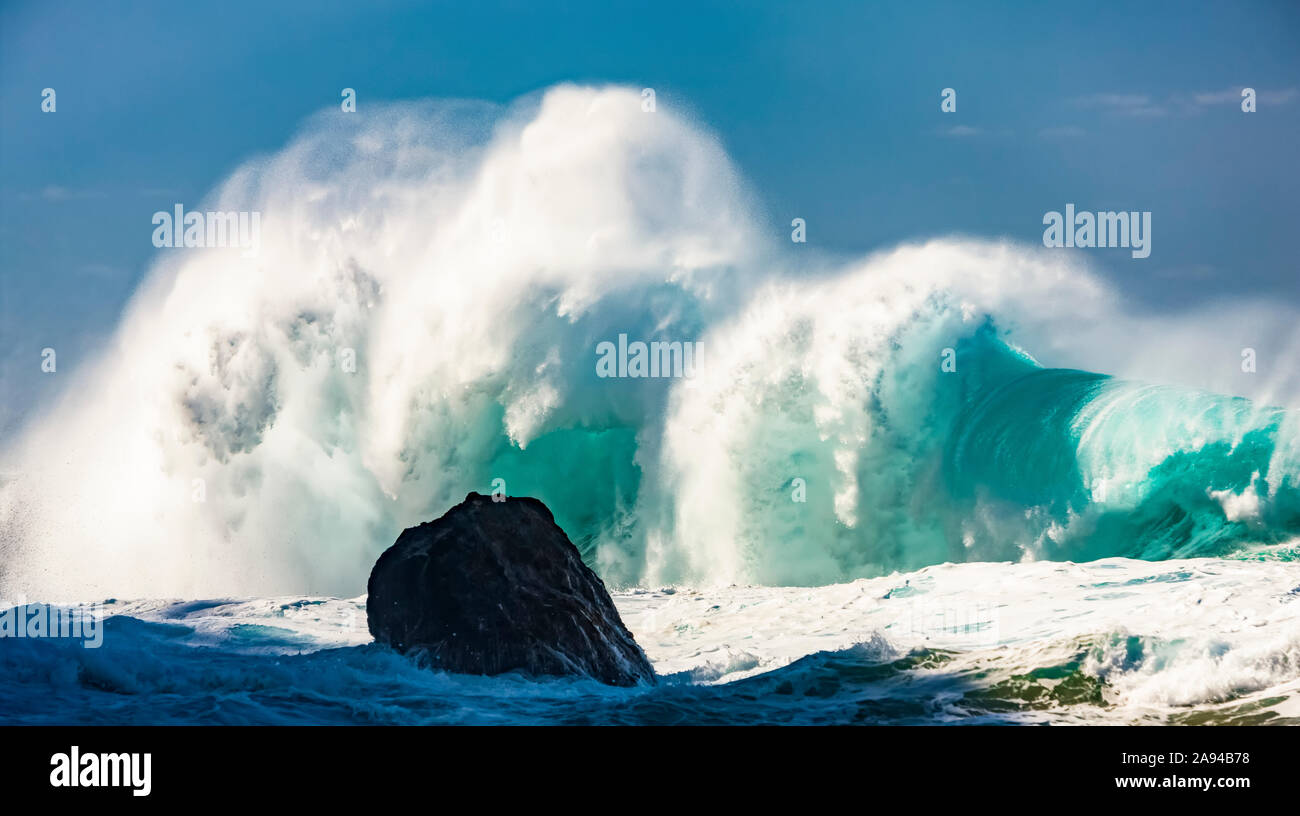 Schiantando una grande onda contro un cielo blu; Hawaii, Stati Uniti d'America Foto Stock