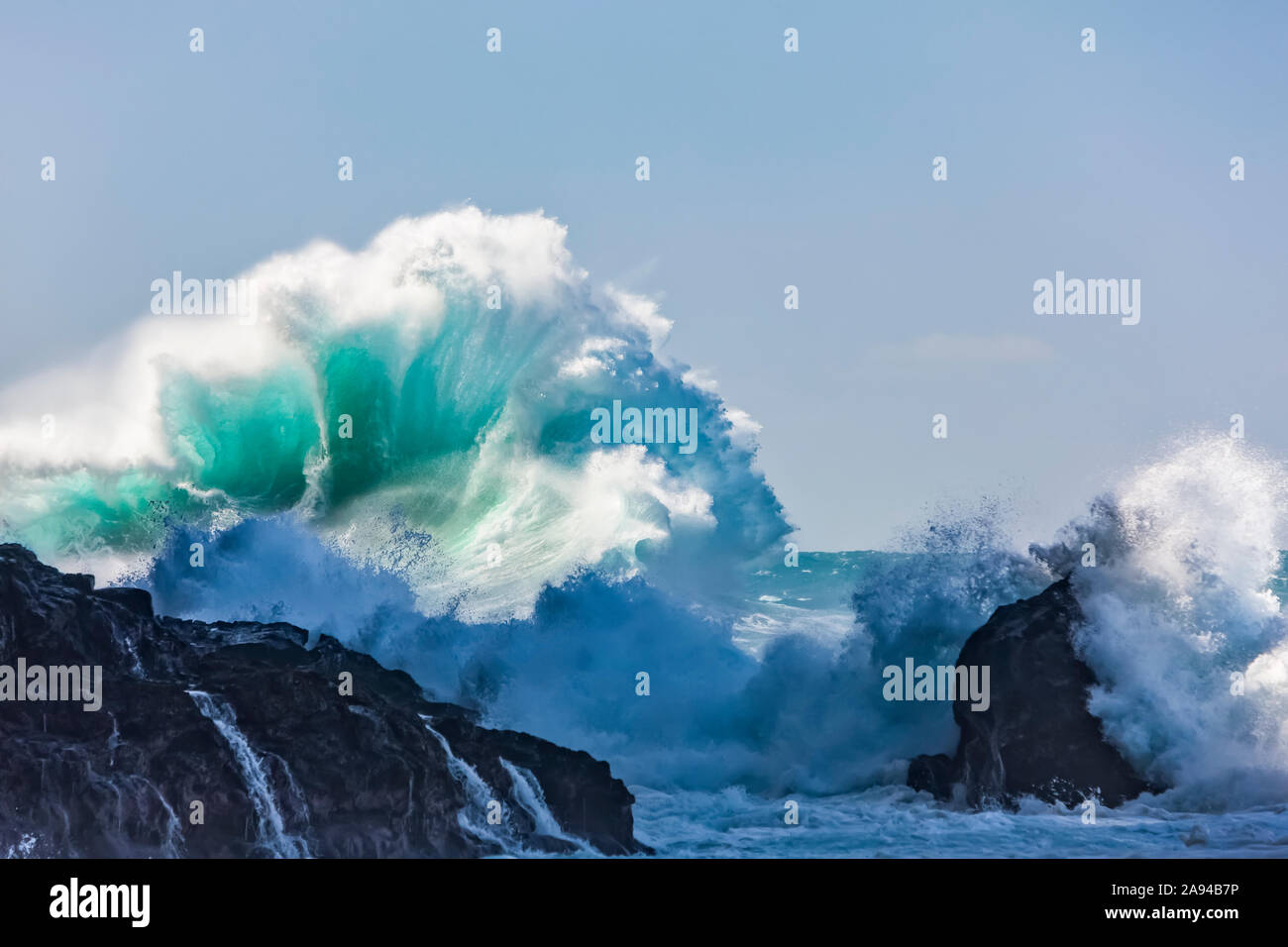 Schiantando una grande onda contro un cielo blu, Hanakapiai Beach; Kauai, Hawaii, Stati Uniti d'America Foto Stock