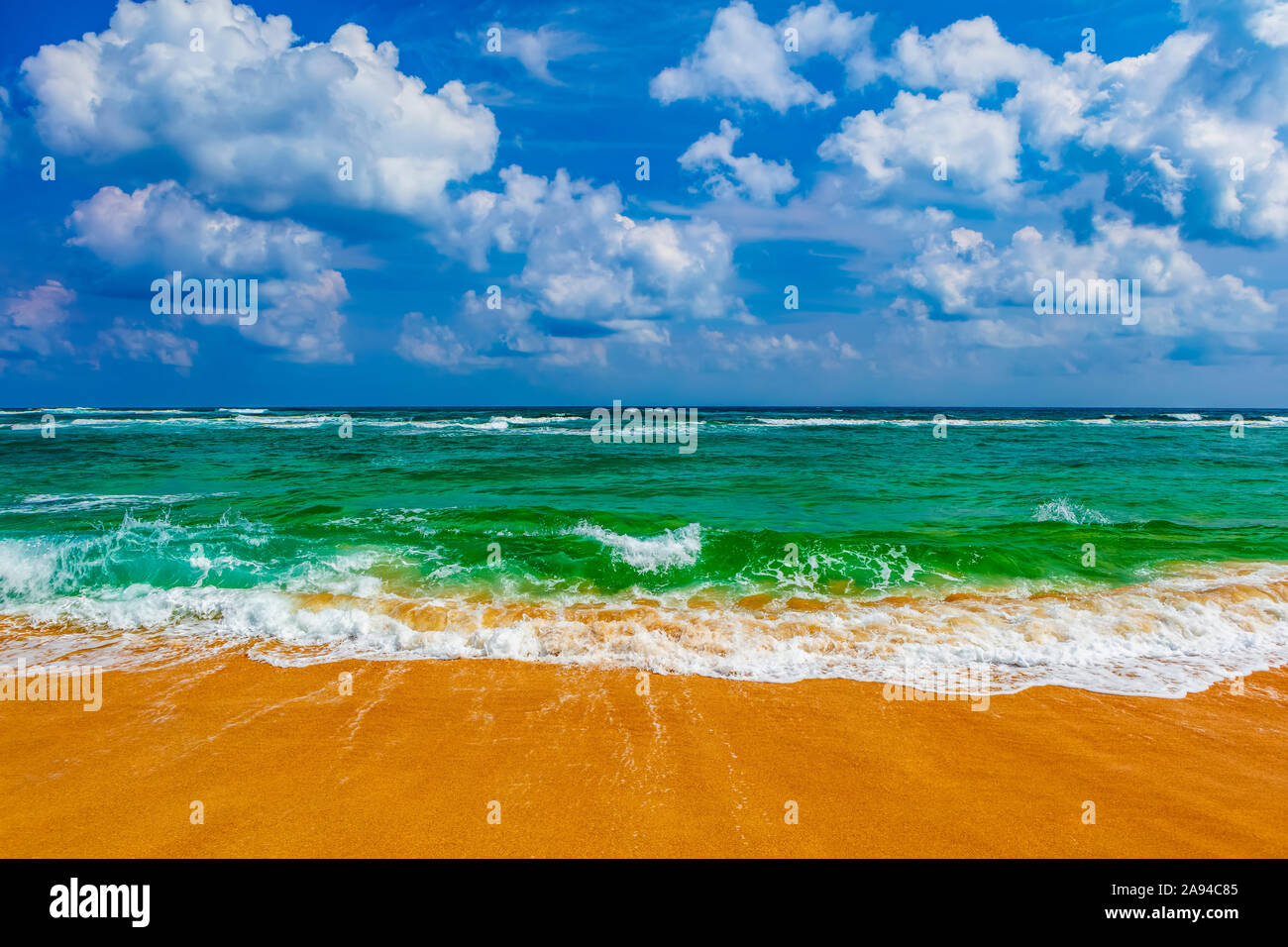 Acque turchesi dell'oceano pacifico che si lavano sulla spiaggia di sabbia dorata; Hawaii, Stati Uniti d'America Foto Stock