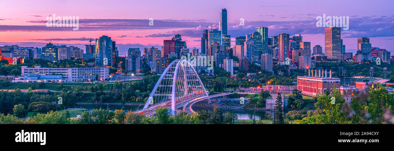 Skyline di Edmonton al tramonto con un bagliore rosa e. Il ponte di Walterdale che attraversa il fiume Saskatchewan nord nel Valle del fiume Foto Stock