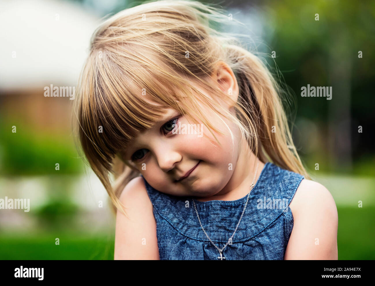 Ritratto di una giovane ragazza carina con capelli biondi che guarda giù nello shyness; Edmonton, Alberta, Canada Foto Stock