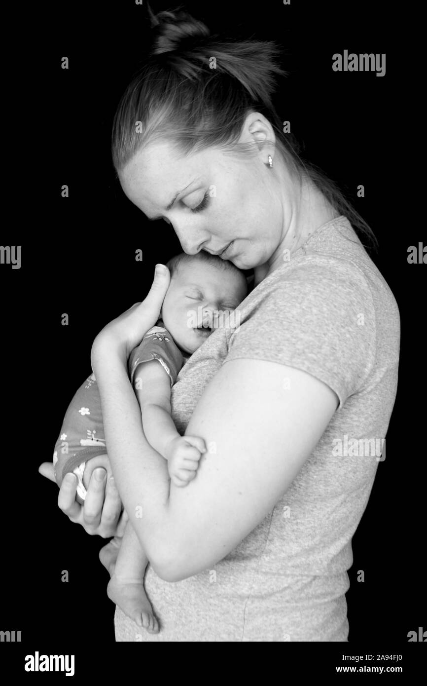 Ritratto del neonato che dorme nelle braccia della madre; Vancouver, British Columbia, Canada Foto Stock