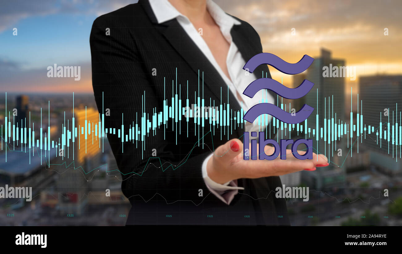 Imprenditrice presentando la Libra cryptocurrency logo su sfondo di architettura moderna Foto Stock