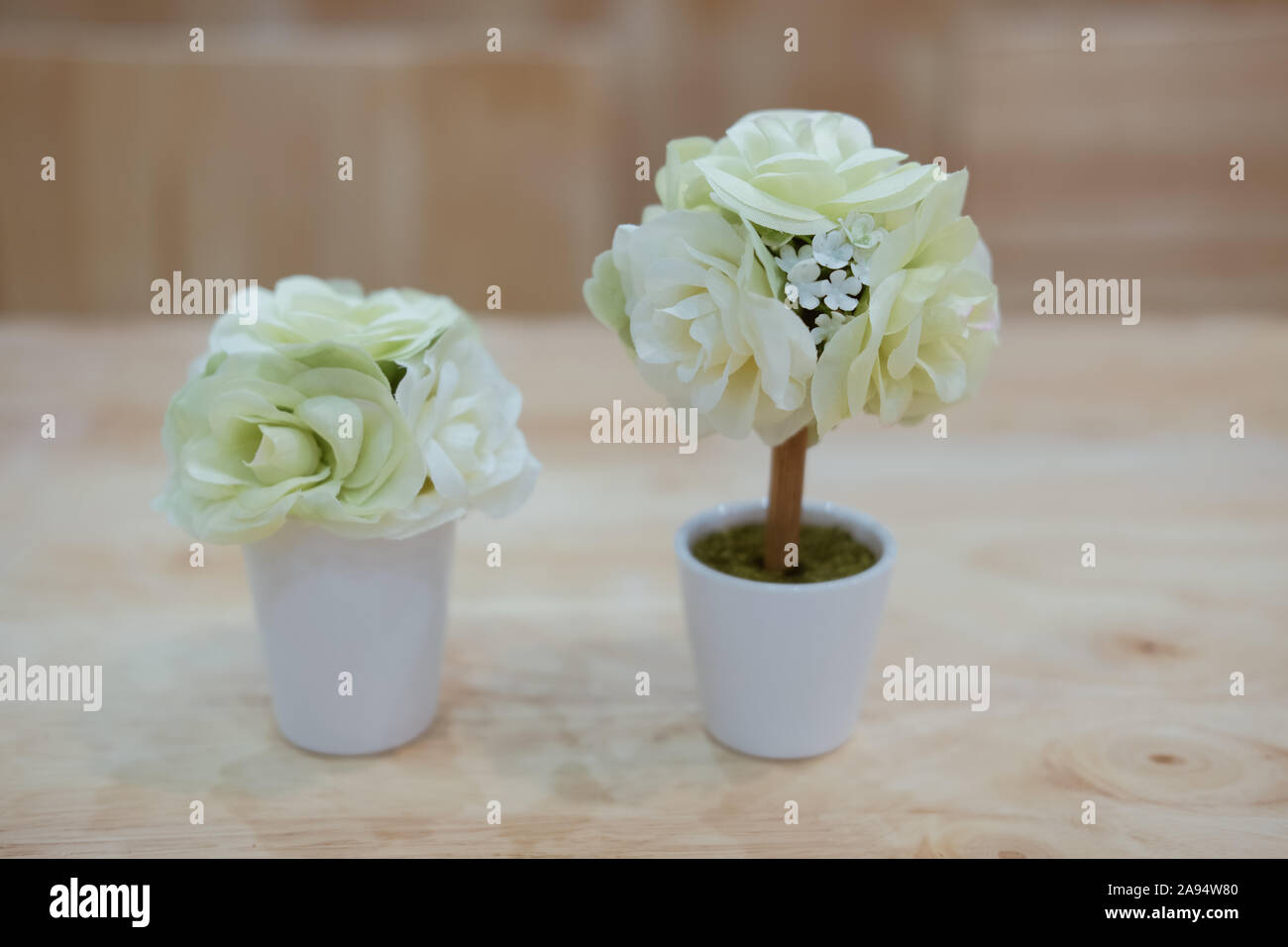 Artificiale rosa bianco fiore in vaso la decorazione sulla scrivania in legno Foto Stock