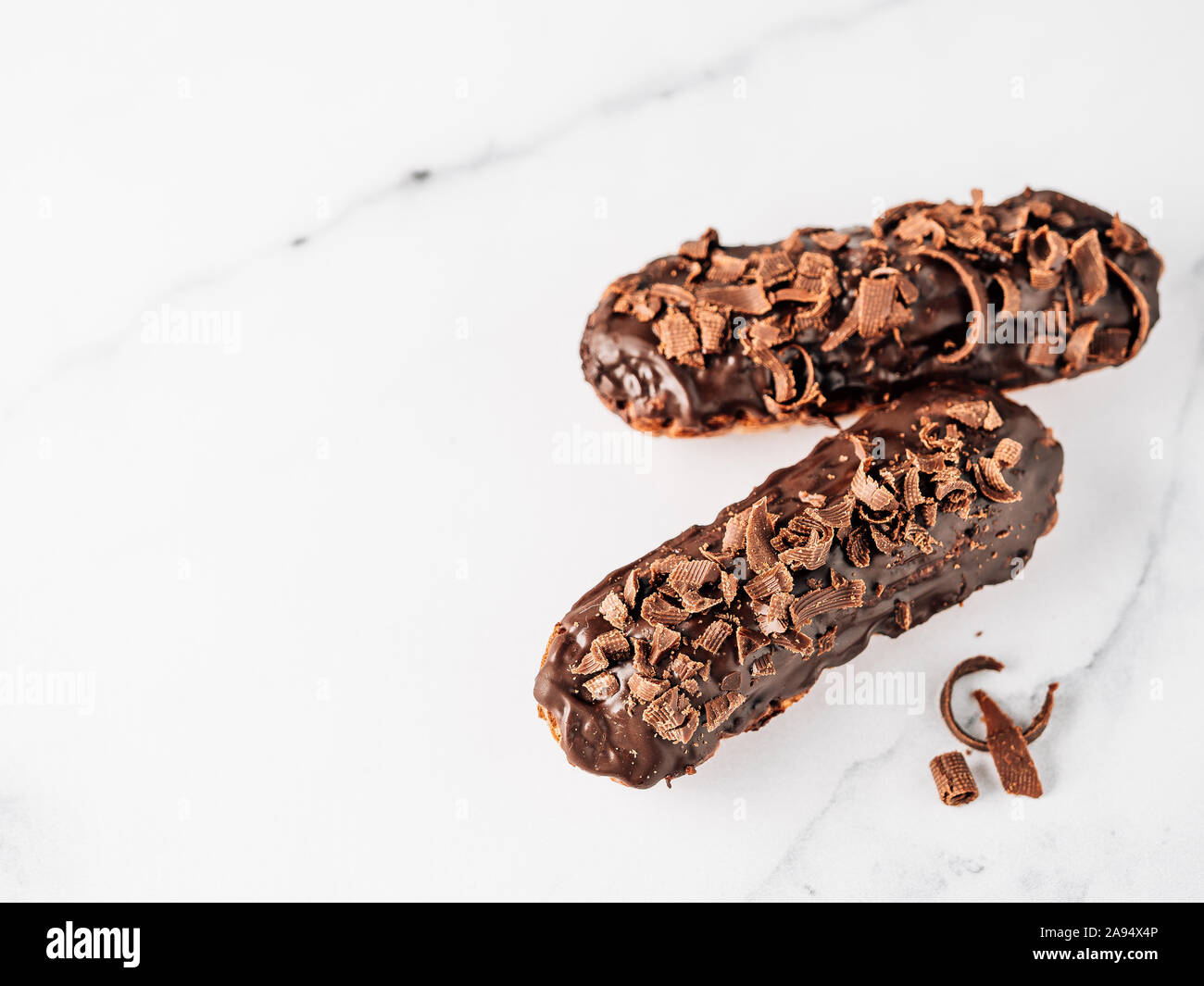 Set di eclairs fatti in casa con cioccolato bianco su sfondo marmo. Vista ravvicinata della deliziosa profitroles sani con glassa di cioccolato. Copia spazio per il testo o il design. Banner Foto Stock