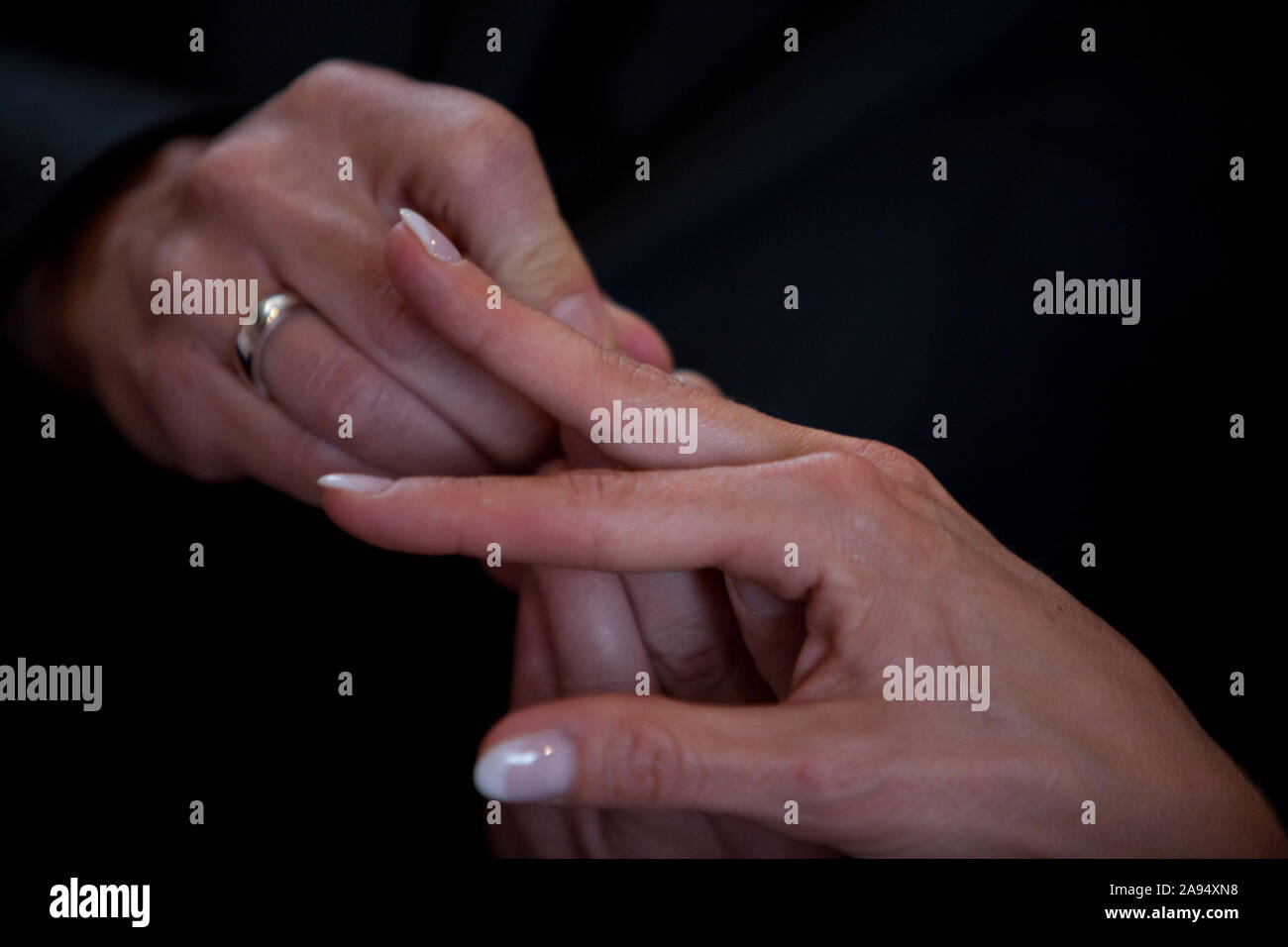 Un irriconoscibile sposa e lo sposo lo scambio degli anelli di nozze nella chiesa durante il cristiano la cerimonia nuziale Foto Stock