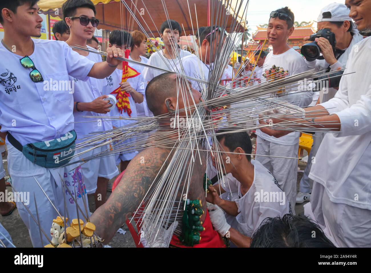 Durante il Vegetarian Festival nella città di Phuket, Thailandia, un Mah Song (mezzo spirituale) mostra una moltitudine di raggi di ferro trafugati attraverso labbra e guance Foto Stock