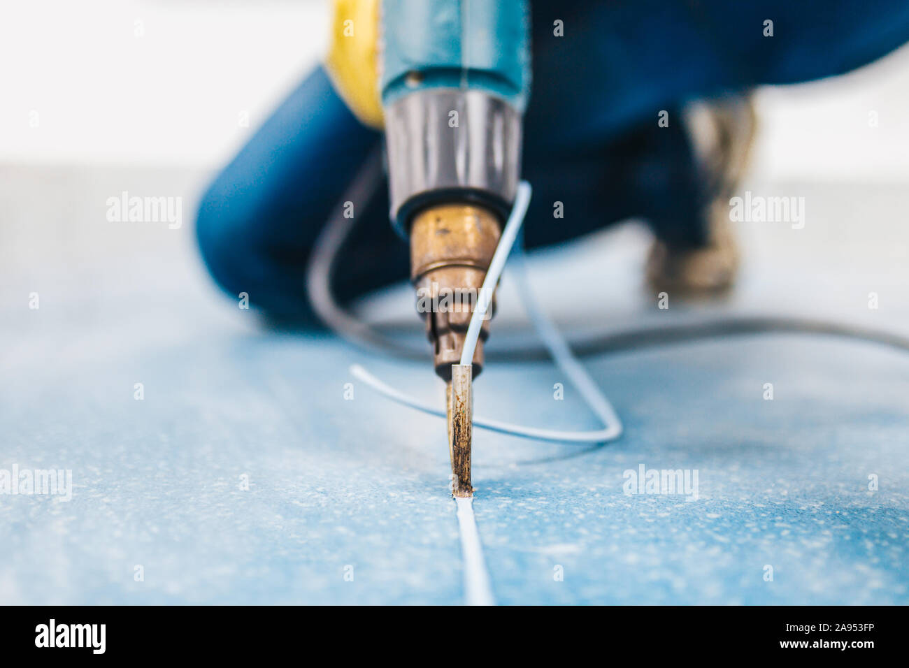 Il Linoleum spike tecnologia - macchina di saldatura con l'ausilio di aria calda nelle mani di uno specialista Foto Stock
