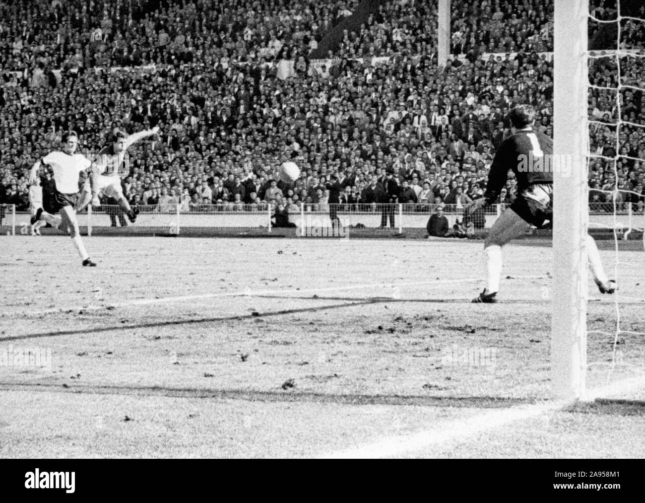 File foto datata 30-07-1966 di Inghilterra del Geoff Hurst crepe un colpo passato portiere tedesco Hans Tilkowski al cliente la meta finale della Coppa del Mondo in finale contro la Germania Ovest a Wembley. Foto Stock