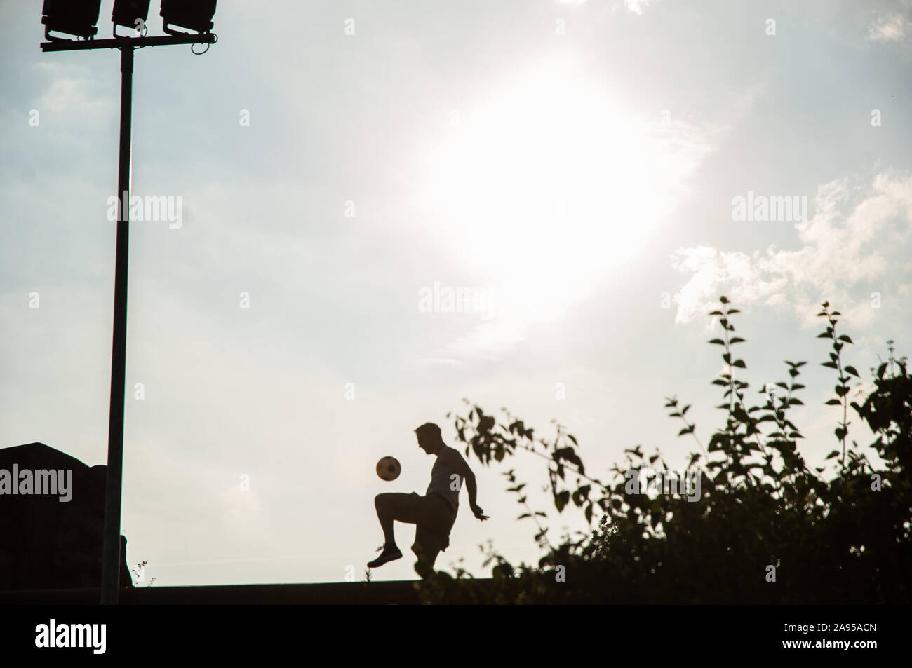 Fußballspieler im gegenlicht Foto Stock