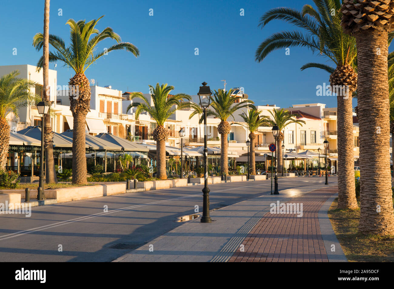 Rethymno, Creta, Grecia. Vista lungo il lungomare costeggiato da palme, alba. Foto Stock